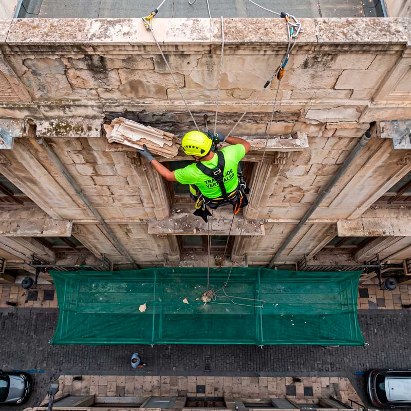 tecnico-quitando-cornisa-de-un-edificio-con-humedades